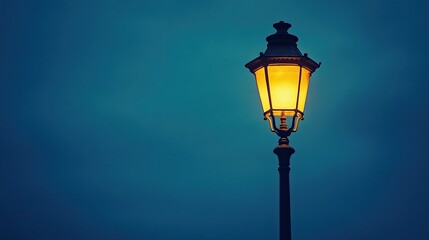 A vintage street lamp glowing warmly, standing alone against a peaceful, deep blue night sky.