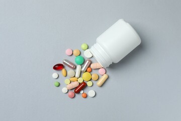 White bottle with pills on a gray background
