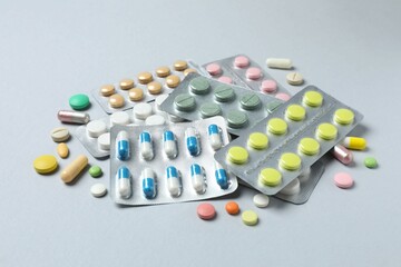 Pills in blister packs on gray  background, close up