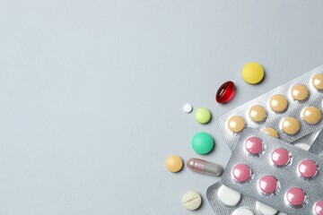 Pills in blister packs on gray  background, close up