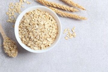 Composition with oatmeal flakes on gray background. Cooking breakfast