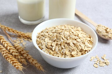Composition with oatmeal flakes on gray background. Cooking breakfast