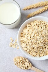 Composition with oatmeal flakes on gray background. Cooking breakfast