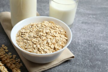 Composition with oatmeal flakes on gray background. Cooking breakfast