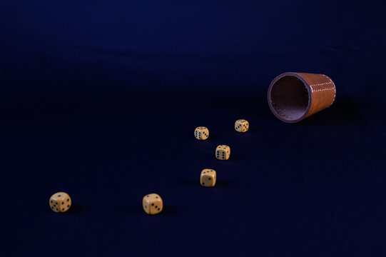 Dice and Cup on Dark Surface Evoking Game and Luck Concepts