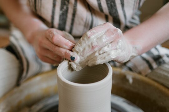 Close-up of hands shaping clay on a pottery wheel