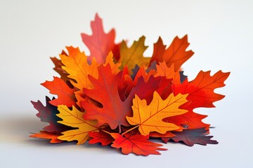 A close-up shot of a pile of autumn leaves on a clean white surface