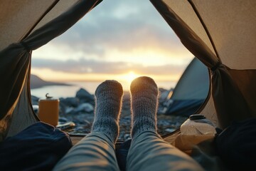 A person is lying down in a tent with their feet up, enjoying some downtime