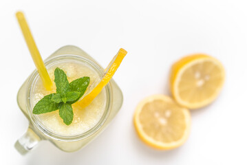 Isolated drink. Glass of lemonade or lemon juice with fresh lemons and straw in jar on white...