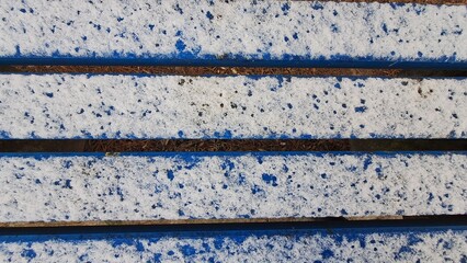 Winter Scene: Blue Bench with Snow and Pine Needles