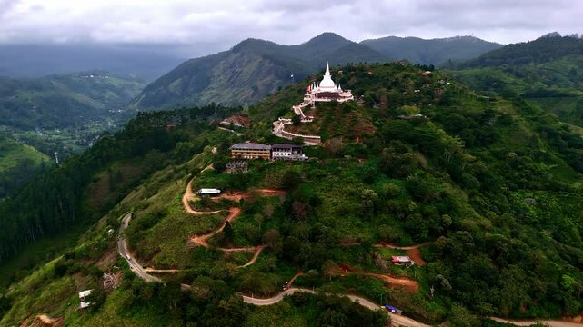 Orbit drone shot of Mahamevnawa Buddhist Monastery in the day in Kumbalwela, Sri Lanka