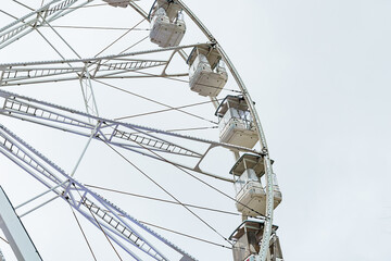 Majestic Ferris wheel rises above the skyline, inviting all to enjoy a thrilling view beneath the cloudy sky