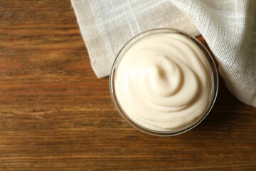 Bowl with mayonnaise on wooden background