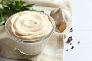 Bowl with mayonnaise and ingredients for cooking on wooden background