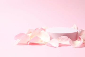 Pink rose petals with podium on a color background