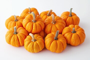 Pile of small orange pumpkins on a white surface