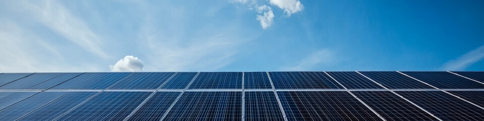 Obraz premium Solar panels under a clear blue sky, capturing sunlight. Concept of renewable energy and sustainability. For energy and environment-related projects.