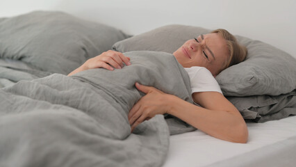 Young Woman with Back Pain while Sleeping in Bed