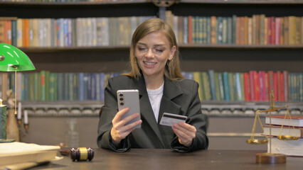 Female Lawyer Shopping Online with Credit Card and Phone in Office