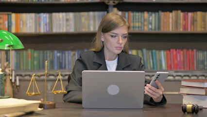 Female Lawyer Using Phone with Laptop