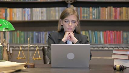 Pensive Female Lawyer Reading on Laptop