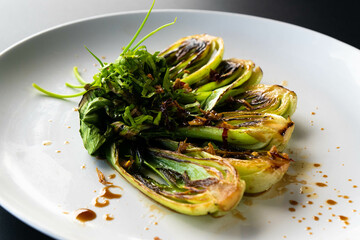 Fresh bok choy is elegantly plated, showcasing a vibrant green garnish inspired by Asian cuisine.