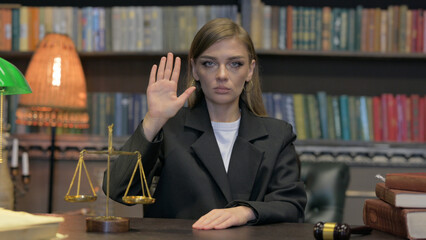 Portrait of Female Lawyer with Stop Gesture Sitting in Office