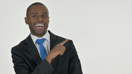 Portrait of Pointing African Businessman Showing Copyspace on White Background