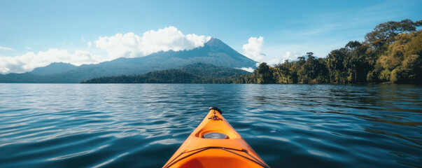 kayak on calm lake, majestic volcano in background, vibrant orange kayak bow, lush green shoreline, clear blue water, tranquil mountain scenery, pristine nature, adventure photography, wide-angle view