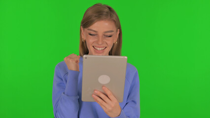 Fototapeta premium Woman Celebrating Success on Tablet on Green Background