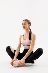 Fototapeta premium Woman stretching in a fitness studio during a morning workout session to maintain flexibility and enhance performance