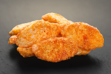 Rusks with spices. Fried croutons close-up. Heap of croutons on dark