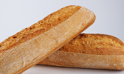 Baguette, two loaves crossed on a white background. Two baguettes on a white background.