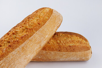 Baguette, two loaves crossed on a white background. Two baguettes on a white background.