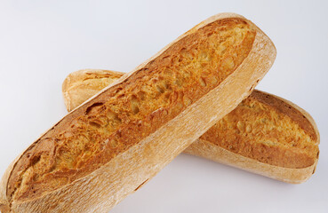 Baguette, two loaves crossed on a white background. Two baguettes on a white background.