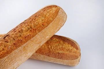 Baguette, two loaves crossed on a white background. Two baguettes on a white background.