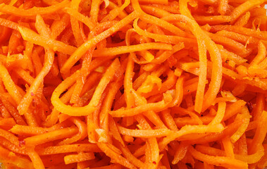 Korean carrots. Salad of orange fresh carrots and spices. Food theme. Carrot background.