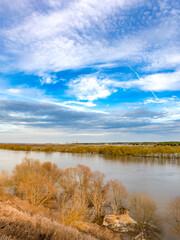 Beautiful blue sky with a few clouds and a river in the background