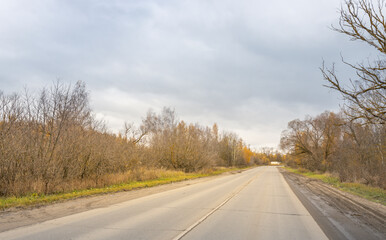 Fototapeta premium A road with trees in the background and a cloudy sky