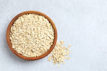 Composition with oatmeal flakes on gray background. Cooking breakfast