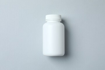 White bottle on gray background, top view