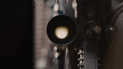 Close ups of a vintage 8MM projector spools moving and playing film 