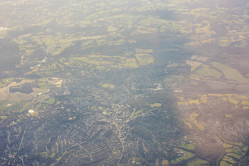 Aerial view of London outskirts lush green fields from an aeroplane window