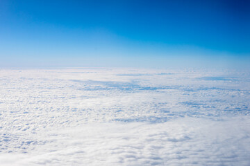 View of clouds from airplane window, clouds in a blue sky