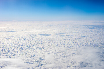 View of clouds from airplane window, clouds in a blue sky