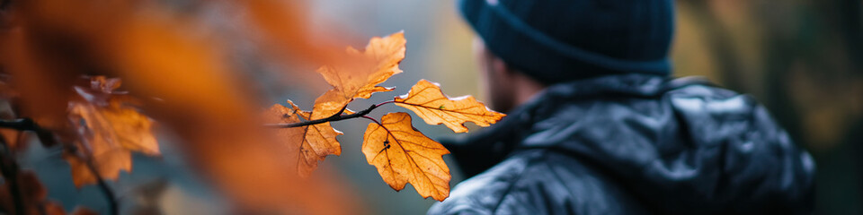 Fototapeta premium Autumn Leaves and Blurred Person in Jacket