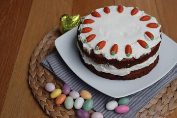 Homemade carrot cake with mascarpone cream cheese icing and mini marzipan carrot decorations with...