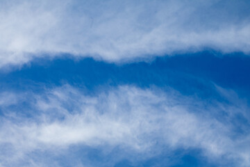 The beautiful and captivating blue sky features soft, wispy clouds that drift gently by