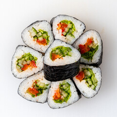 Exquisite Sushi Rolls With Vibrant Vegetables and Fresh Fish Arranged Artfully on a White Plate for a Delightful Culinary Experience