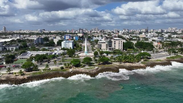 Santo Domingo, Dominican Republic, flying across shoreline toward Monument to the Heroes of Constance, Maimon and Estero Hondo located in park Centro de Los Heroes, 4k aerial video footage